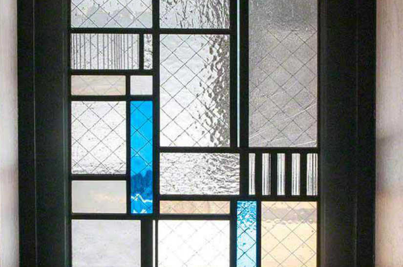 シンプルな3枚一組のステンドグラス。ブルーのガラスを使った右パネルの下の部分のクローズアップ。