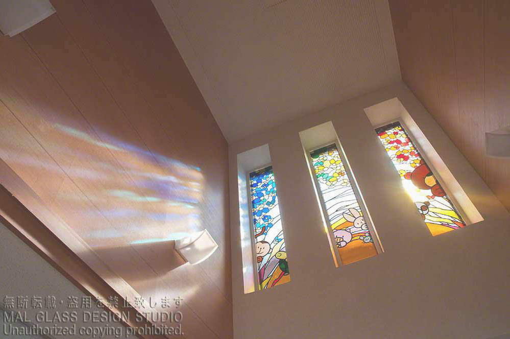 かわいいステンドグラスの施工例。3枚一組のステンドグラスと壁面に映る影。