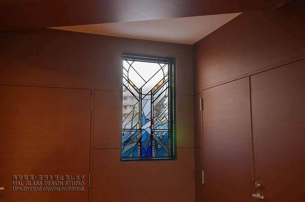 西壁面に取りつけられたアルファベットの「Y」の字をアレンジしたステンドグラス。