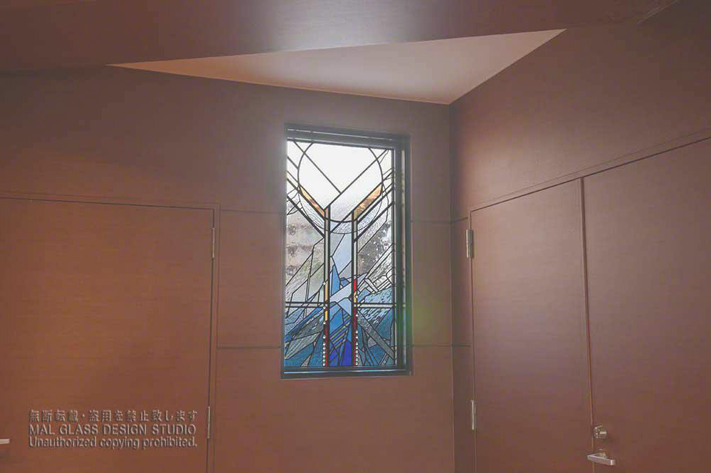 西壁面に取りつけられたアルファベットの「Y」の字をアレンジしたステンドグラス。